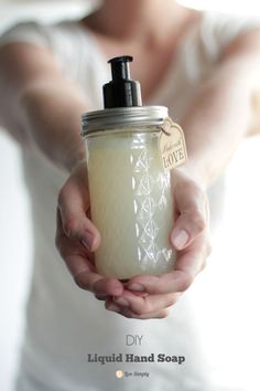 a person holding a jar filled with liquid