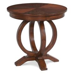 a round wooden table with an intricate design on the top and bottom, against a white background