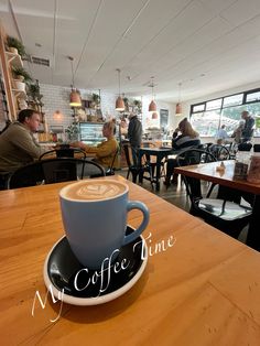 a cup of coffee sitting on top of a saucer next to a wooden table