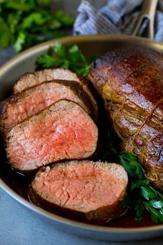 some meat and greens in a bowl on a table