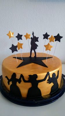 a yellow cake with black silhouettes and stars on top