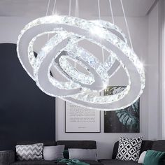 a modern chandelier hanging from the ceiling in a living room