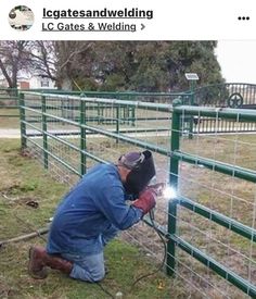 a man working on a fence in the grass