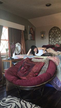 a woman laying on top of a bed in a bedroom