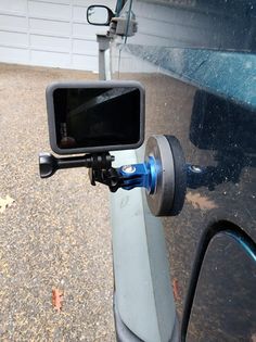 there is a car mirror with a blue handlebar attached to the side of it