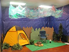 a tent set up in the middle of a room with trees and mountains on it