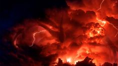 a large cloud filled with lots of red and orange lightnings in the night sky