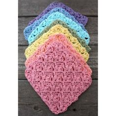 six crocheted dishcloths on wooden surface