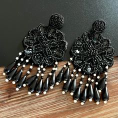 Bohemian Vibes Earrings- Ethically handcrafted, these Floral Black Beaded bohemian-style earrings feature intricate embroidery and dazzling beadwork. Designed with fine detailing, they are the perfect accessory to complement any outfit for any occasion. Specifications and Dimensions Colour: Black and White Total Length: 4 inches Width: 2 inches Closure: Push-back secured Weight: Very lightweight Materials: Beads and Fabric  Style Tip Pair these earrings with a flowy maxi dress or a casual chic o Beaded Bohemian Chandelier Earrings For Party, Bohemian Beaded Chandelier Earrings For Party, Beaded Dangle Chandelier Earrings For Party, Handmade Drop Clip-on Earrings For Party, Traditional Drop Clip-on Earrings For Party, Party Beaded Chandelier Earrings, Bohemian Teardrop Chandelier Earrings For Party, Handmade Party Clip-on Earrings, Handmade Party Chandelier Drop Earrings