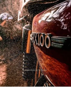 the front end of a red motorcycle covered in sand and water as it speeds through the air