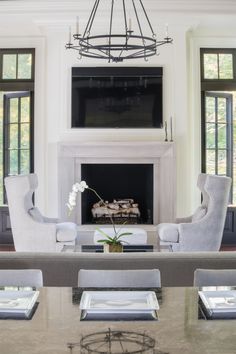 a living room with a fireplace and chairs