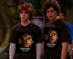 two young men standing next to each other wearing t - shirts with the same image on them