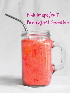 a pink grapefruit breakfast smoothie in a mason jar with a spoon inside