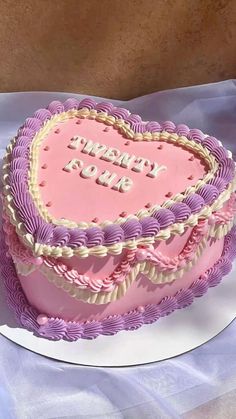 a pink heart shaped cake on top of a white plate