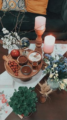 an arrangement of food on a table with candles and flowers