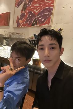 two young men posing for a photo in a kitchen