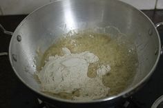 a metal pan filled with flour sitting on top of a stove next to a burner