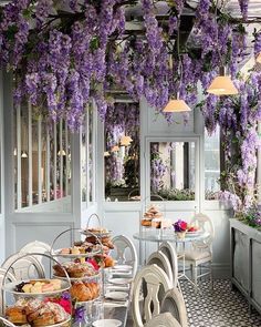 an outdoor dining area with wistery vines hanging from the ceiling