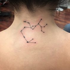 the back of a woman's neck has a small star tattoo on it