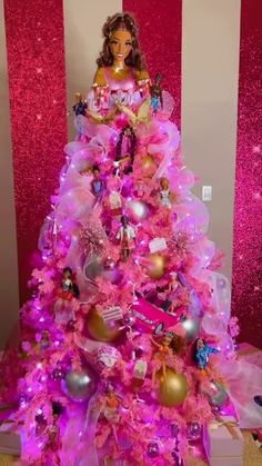 a pink christmas tree with barbie dolls on it