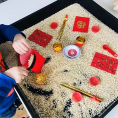 a young boy is playing with his chinese new year's eve craft on the table