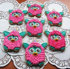 decorated cookies with pink and green frosting on doily