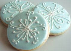 three decorated cookies sitting on top of a table