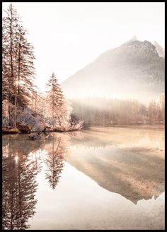 a lake surrounded by trees in front of a mountain