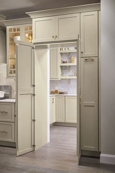 a kitchen with white cabinets and an open door