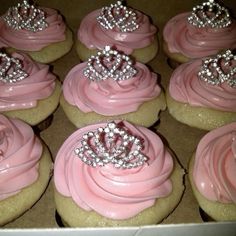 cupcakes with pink frosting and tiara on top are in a box