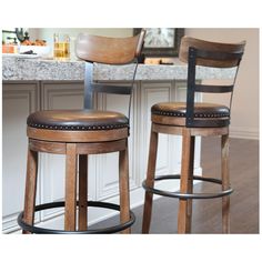 two wooden stools sitting in front of a counter top with a lamp on it