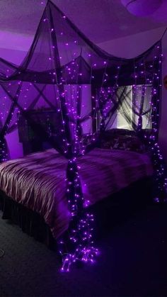 a bed with purple lights on it and a canopy over the headboard is lit up