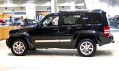 a black jeep is parked in a showroom