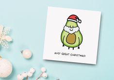 a christmas card with an avocado wearing a santa hat on it's head