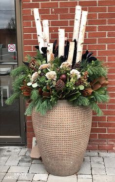 a planter filled with candles and flowers on the side of a brick building next to a door