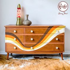 a wooden dresser with two vases sitting on it's top and bottom drawers