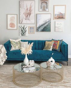 a living room with blue couches and pictures on the wall above them in various frames