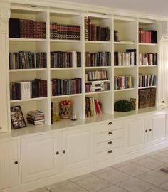 a large white bookcase filled with lots of books on top of it's shelves