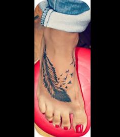 a woman's foot with a feather tattoo on it