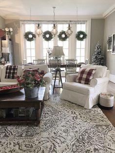 a living room filled with furniture and christmas wreaths