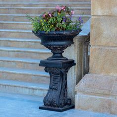 a planter with flowers is sitting on the steps