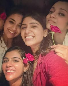 group of people posing for the camera with flowers in their hair