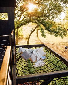 an empty hammock in front of a tree with the sun shining on it