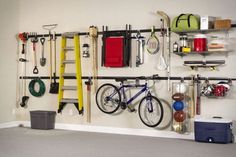 there is a bike hanging on the wall next to some hooks and other things in front of it