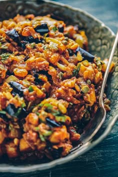 a close up of a bowl of food on a table with a spoon in it