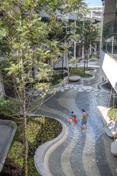 two people are sitting in the middle of a water feature