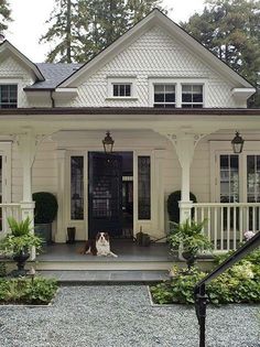 a dog sitting on the front porch of a house