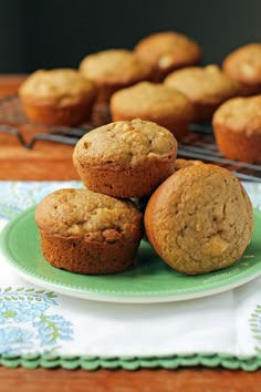 three muffins on a green plate next to other muffins