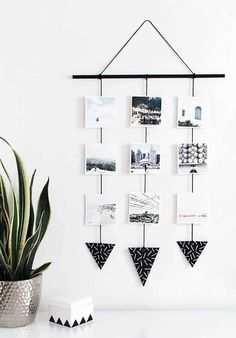 a potted plant sitting on top of a white table next to a wall hanging