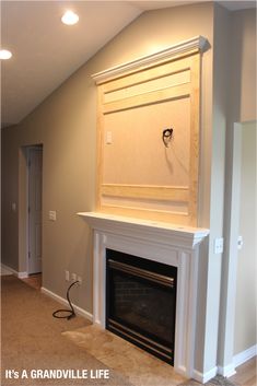 an empty room with a fireplace in the corner and a light on top of it